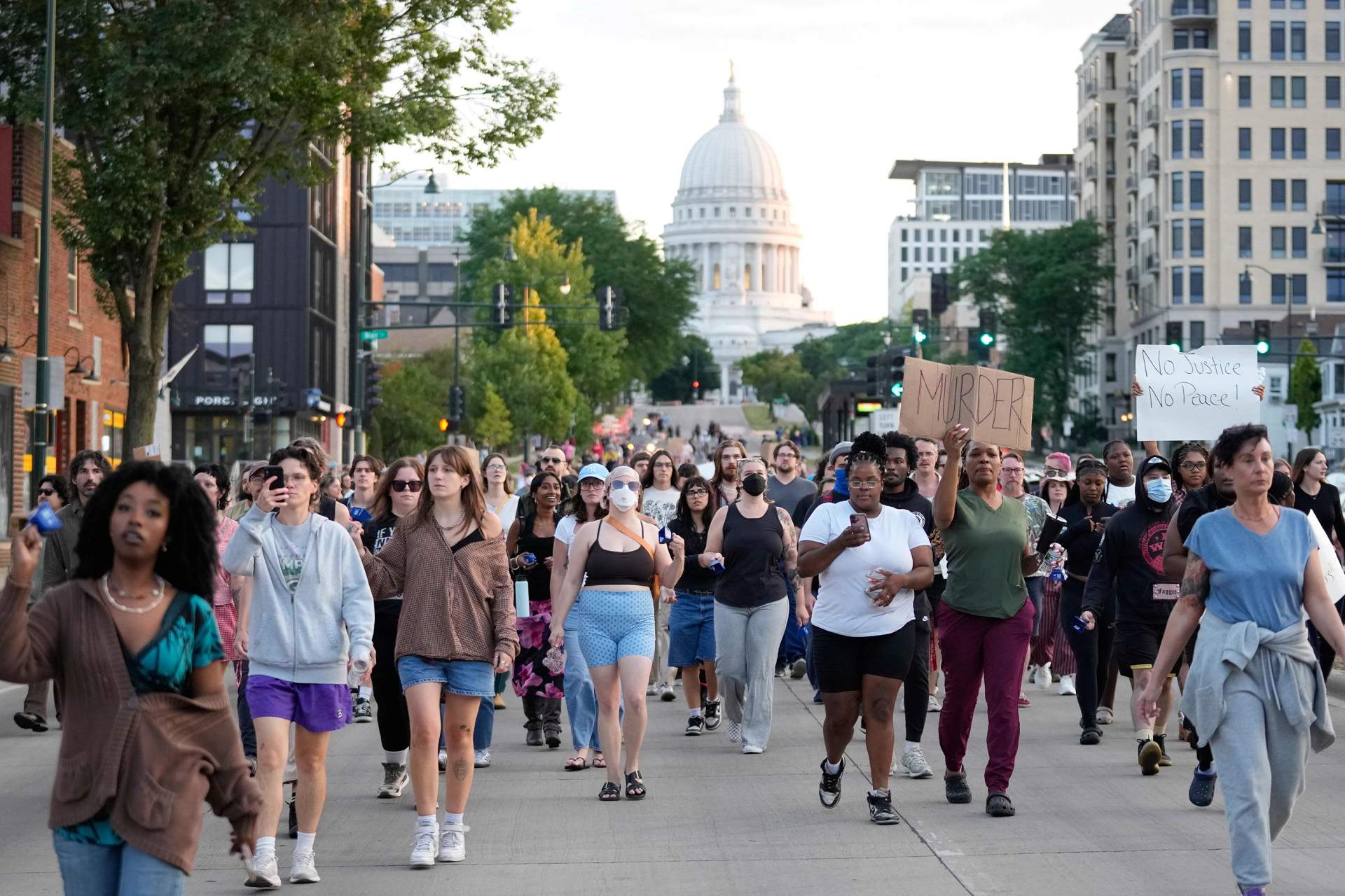 Protesters march past the Wisconsin state Capitol holding signs after the police killing of Corey Ruiz