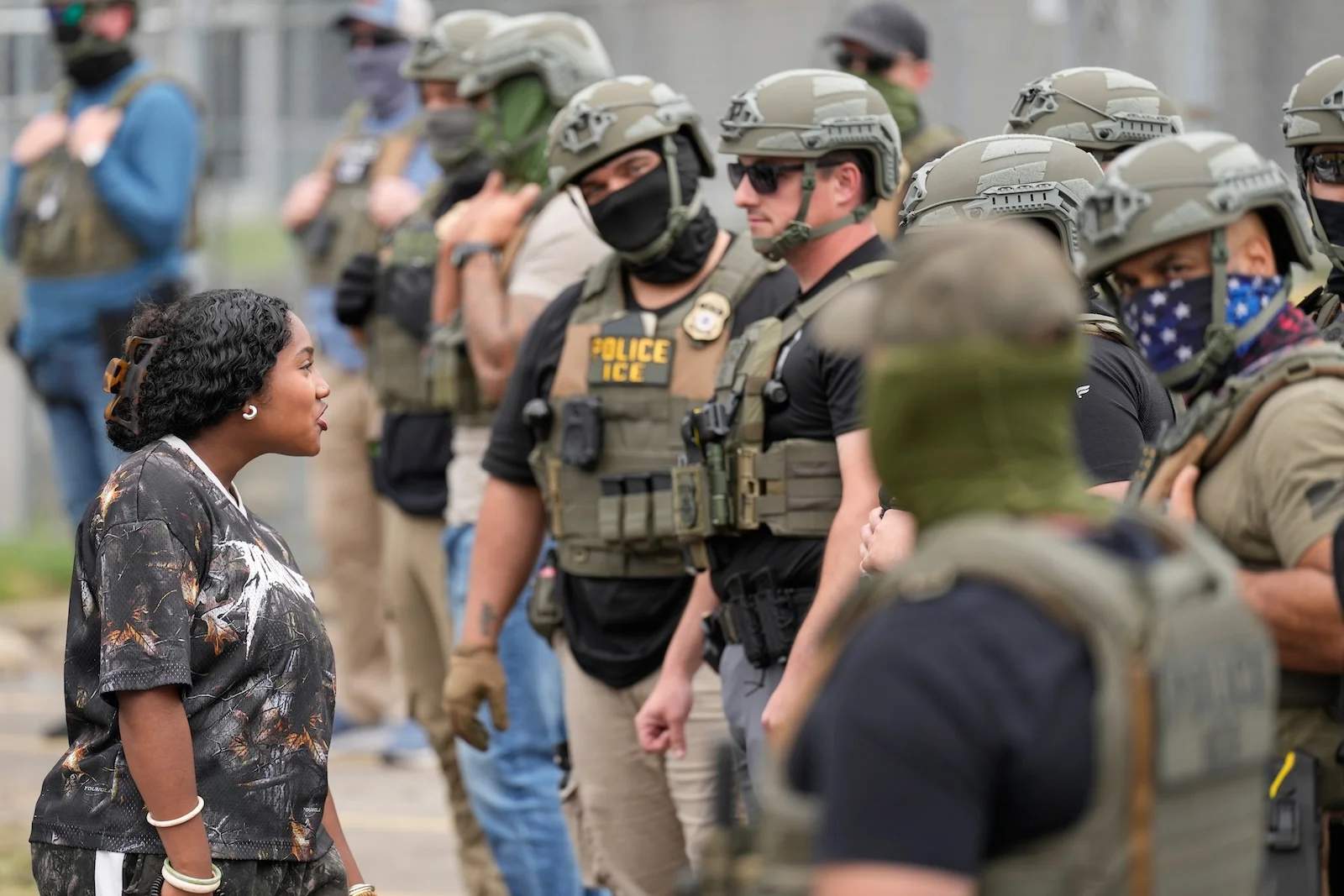 Masked ICE agents form a line outside Delaney Hall during the hunger strike protests