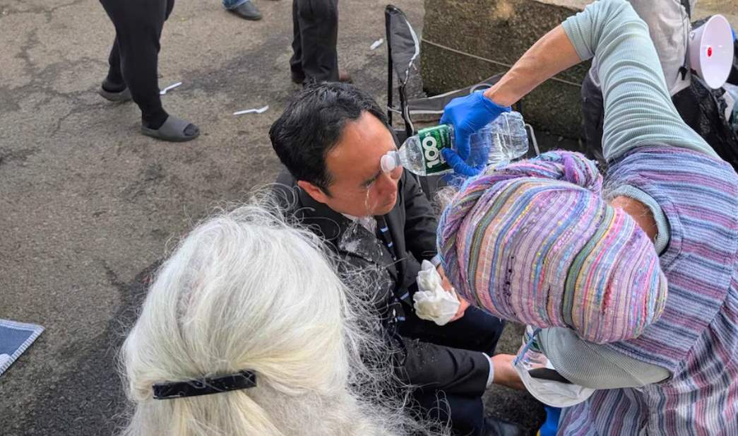 Sen. Andy Kim having pepper ball dust washed out of his eyes.