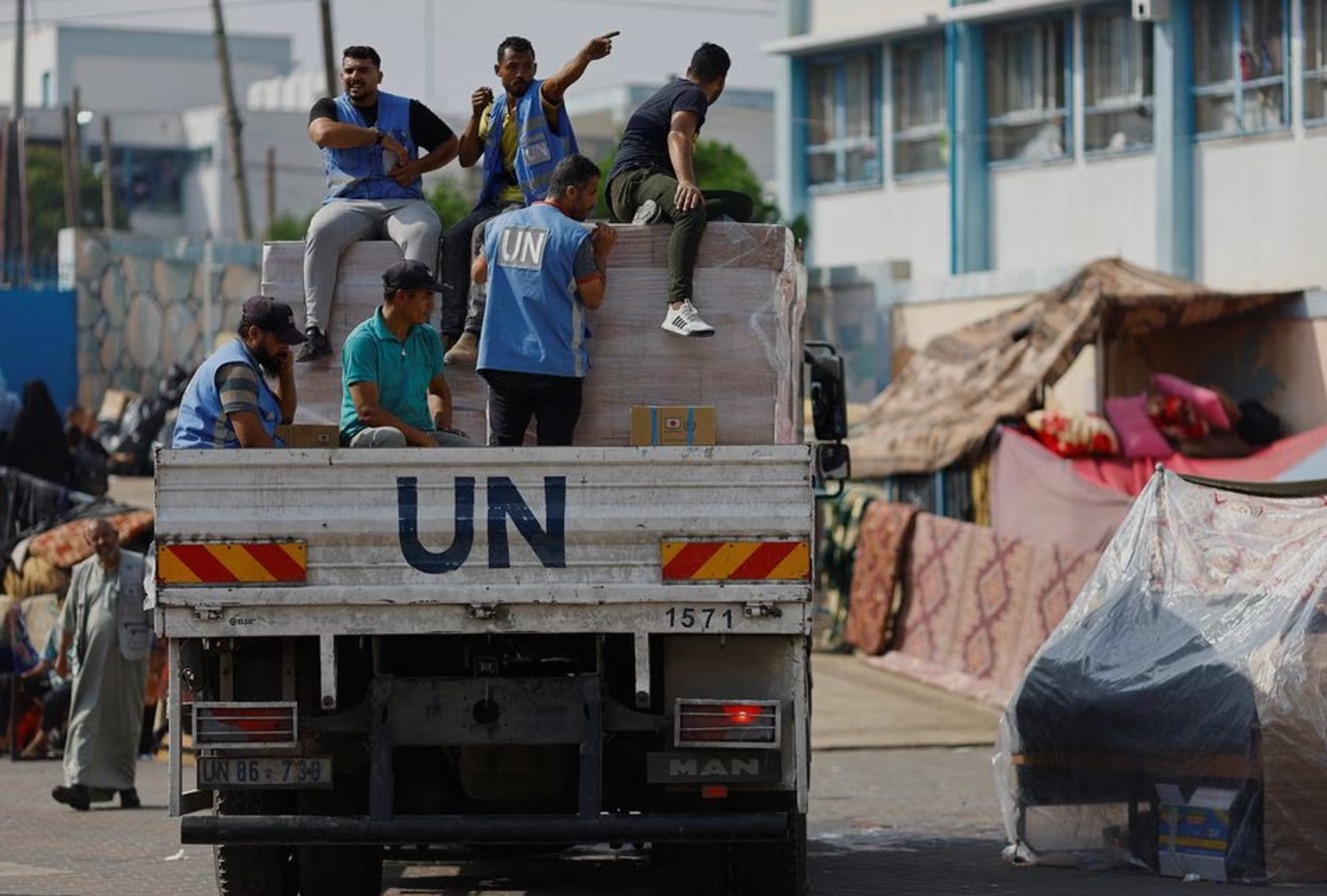United Nations workers arrive to distribute aid to Palestinians, who have fled their homes due to Israeli strikes and take shelter in a UN-run school, in Khan Younis in the southern Gaza Strip October 23, 2023