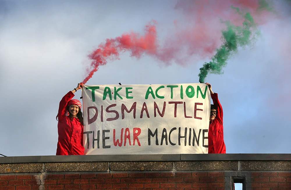 Two Palestine Action protesters on the roof of a weapons factory.