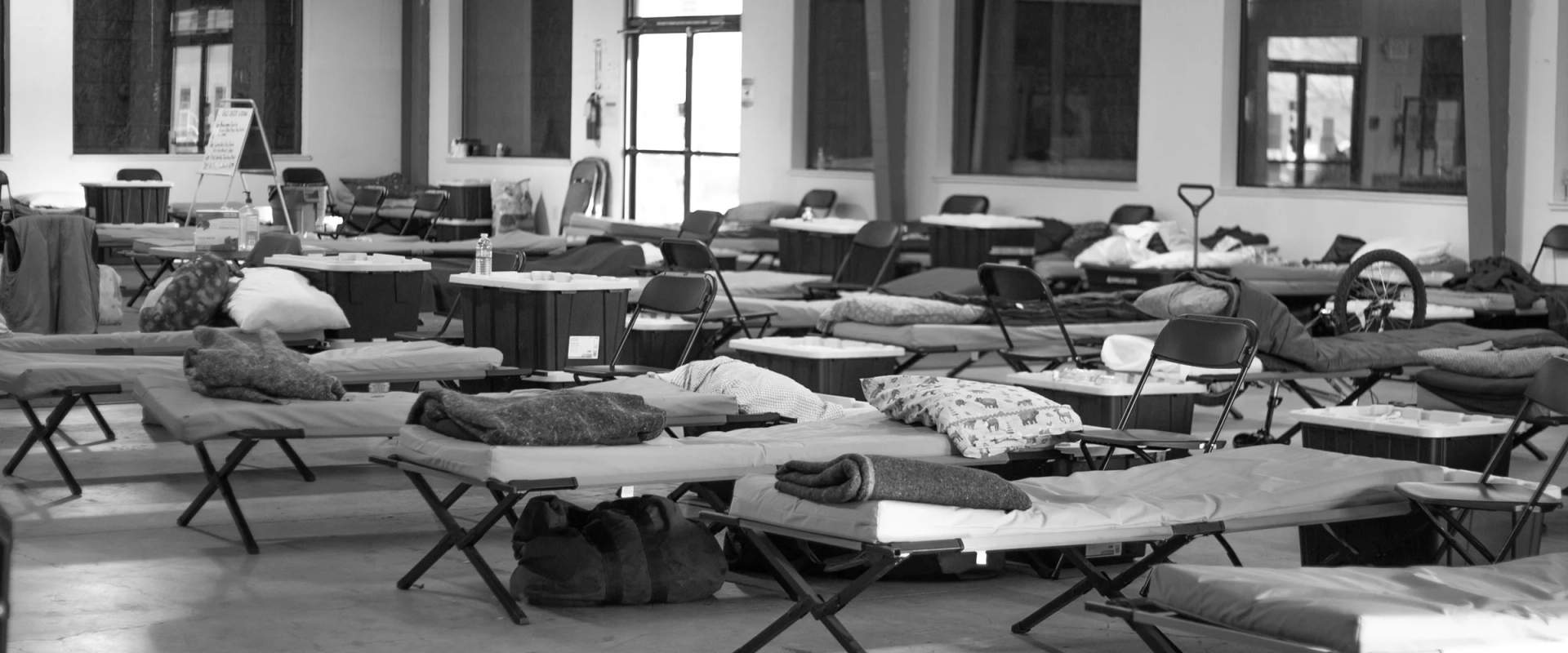 Black and white photograph of an emergency shelter building with people gathered outside in Central Oregon