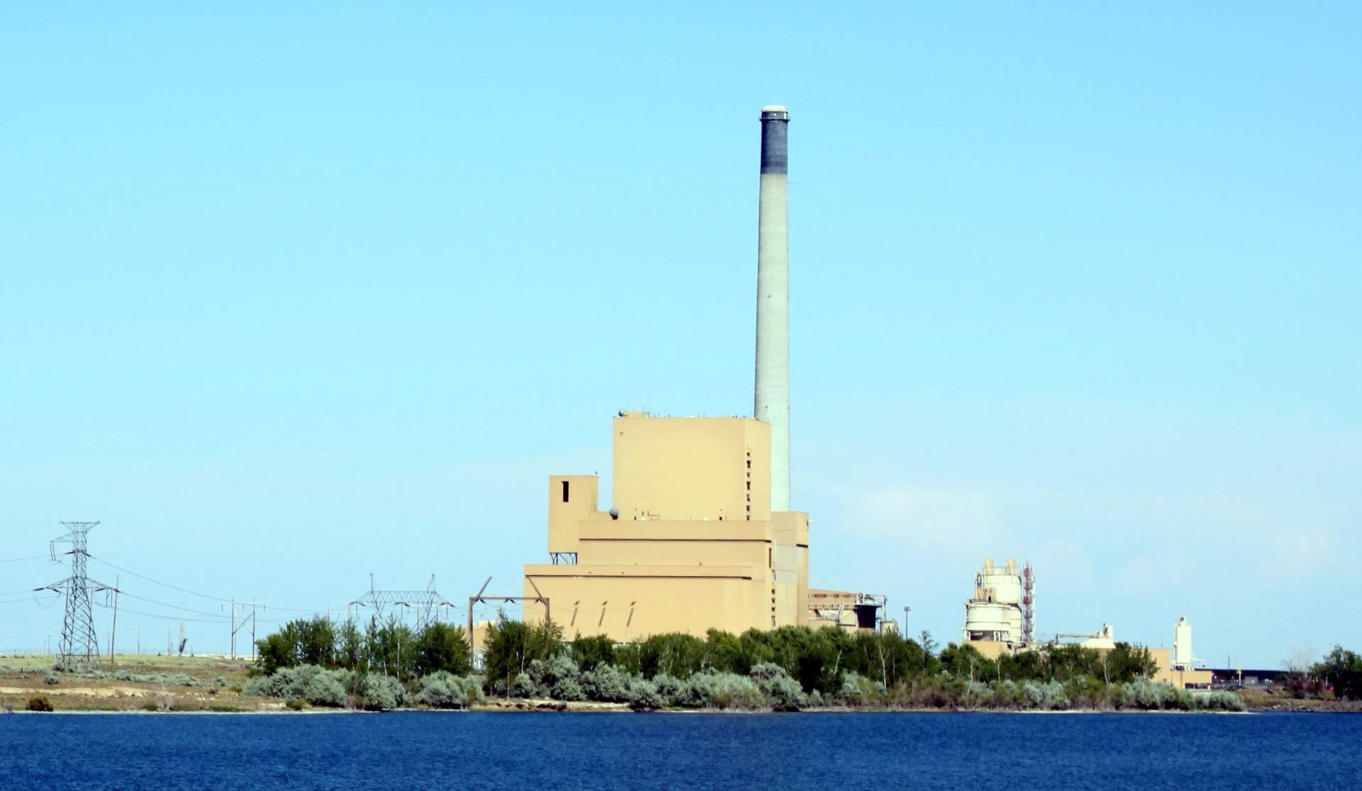 Aerial photograph of the Boardman Coal Plant showing the main power station building with its tall smokestack, surrounded by agricultural land near the Columbia River in eastern Oregon.
