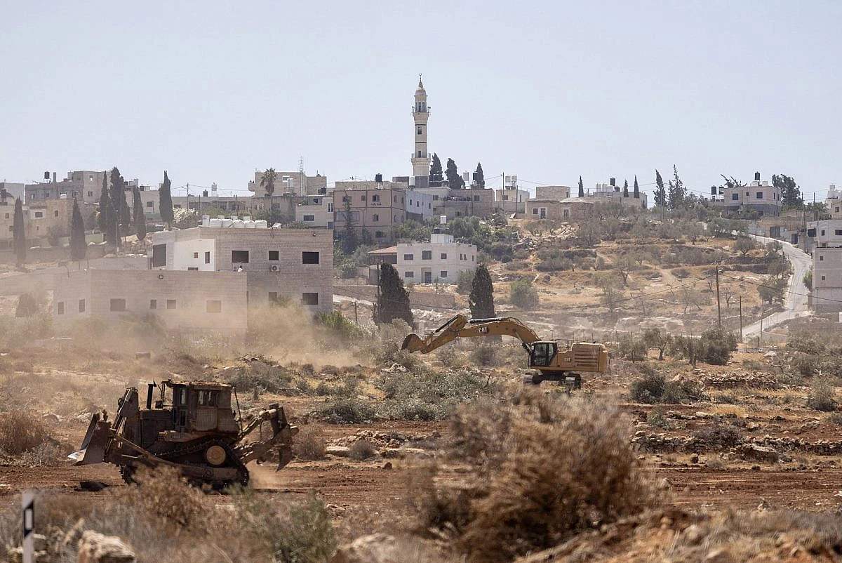Bulldozers operated by Israeli settlers and soldiers uproot olive trees near the village of Al-Mughayyir, in the occupied West Bank, August 23, 2025. (Avishay Mohar/Activestills)