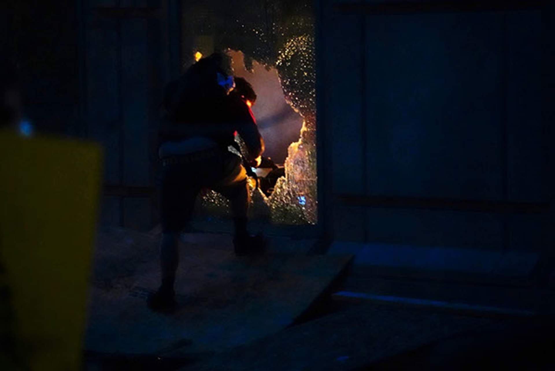 Protester breaking out window of Aurora Courthouse. [Radical Edward - Untelevised Media]