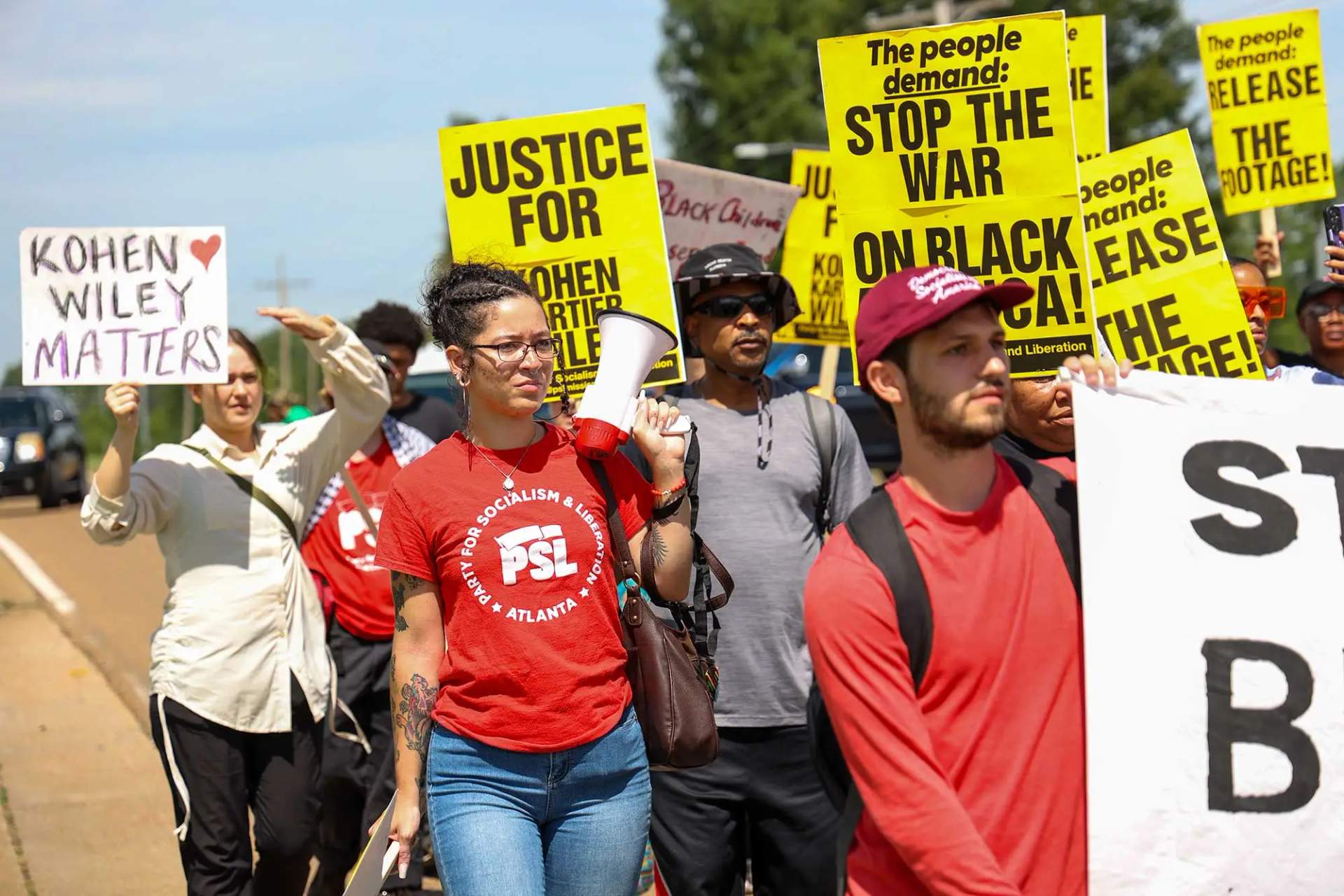 Community members march through downtown Senatobia carrying yellow signs demanding justice for 1-year-old Kohen Wiley on June 26, 2026