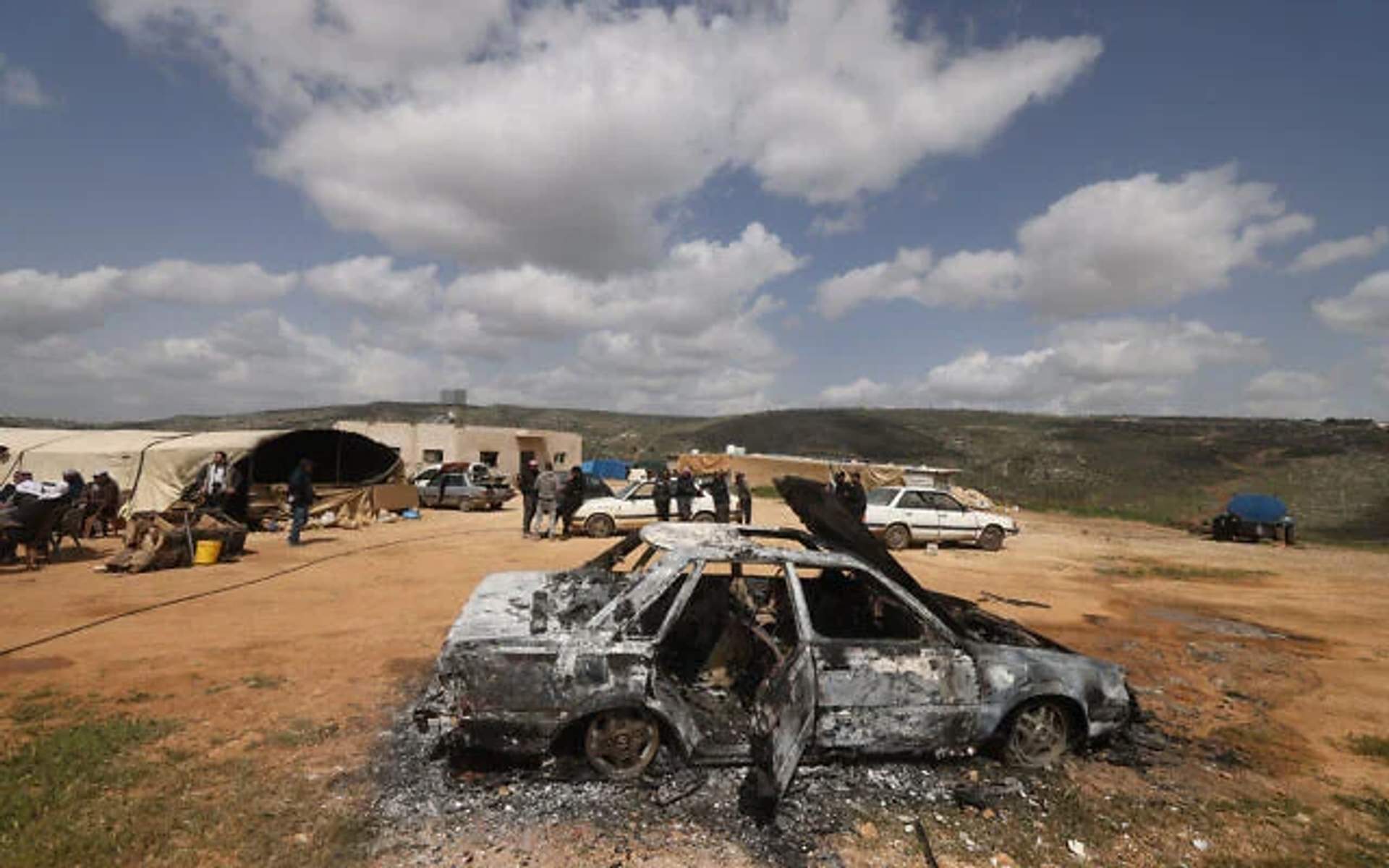 Aftermath of an Israeli settler attack on a Palestinian village in the West Bank, showing destroyed buildings and debris