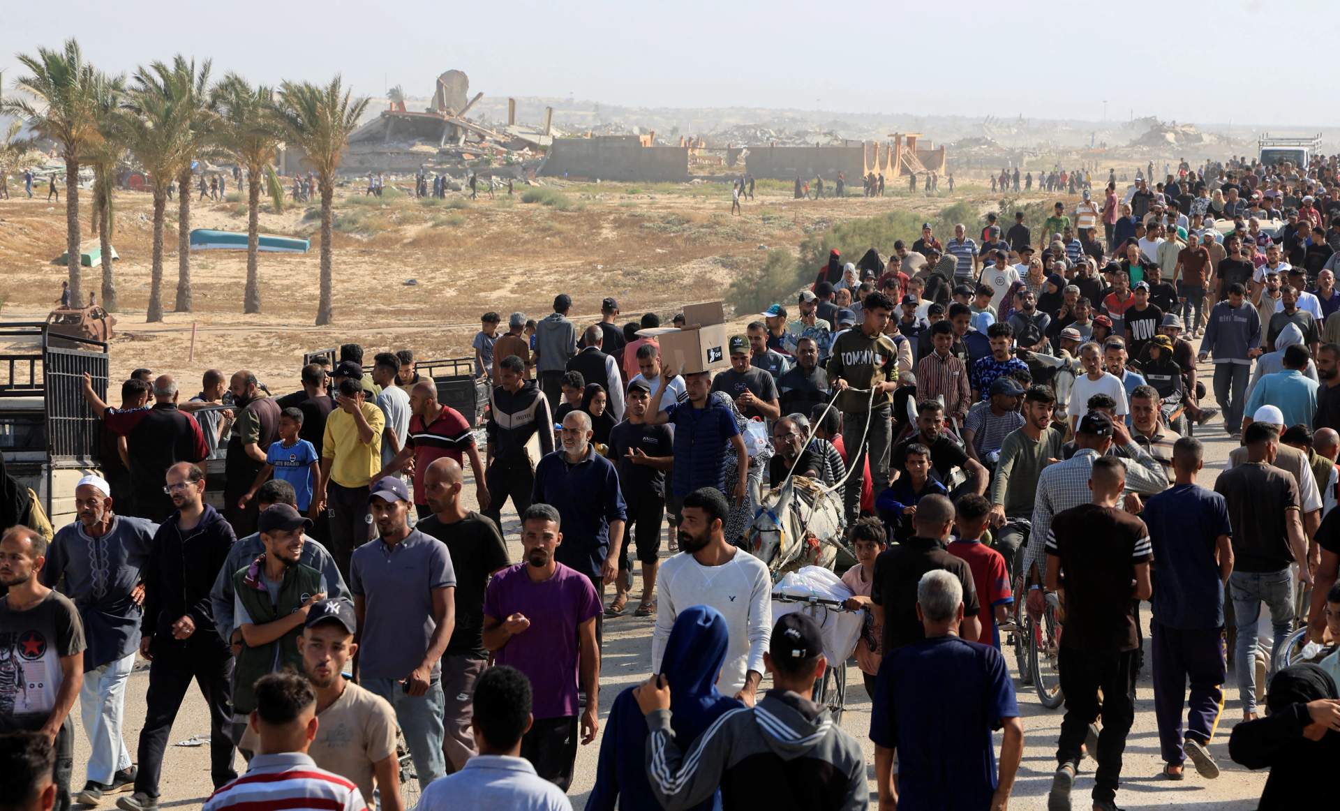 Massive crowd of thousands of Palestinians waiting at an aid distribution point in Gaza during famine conditions