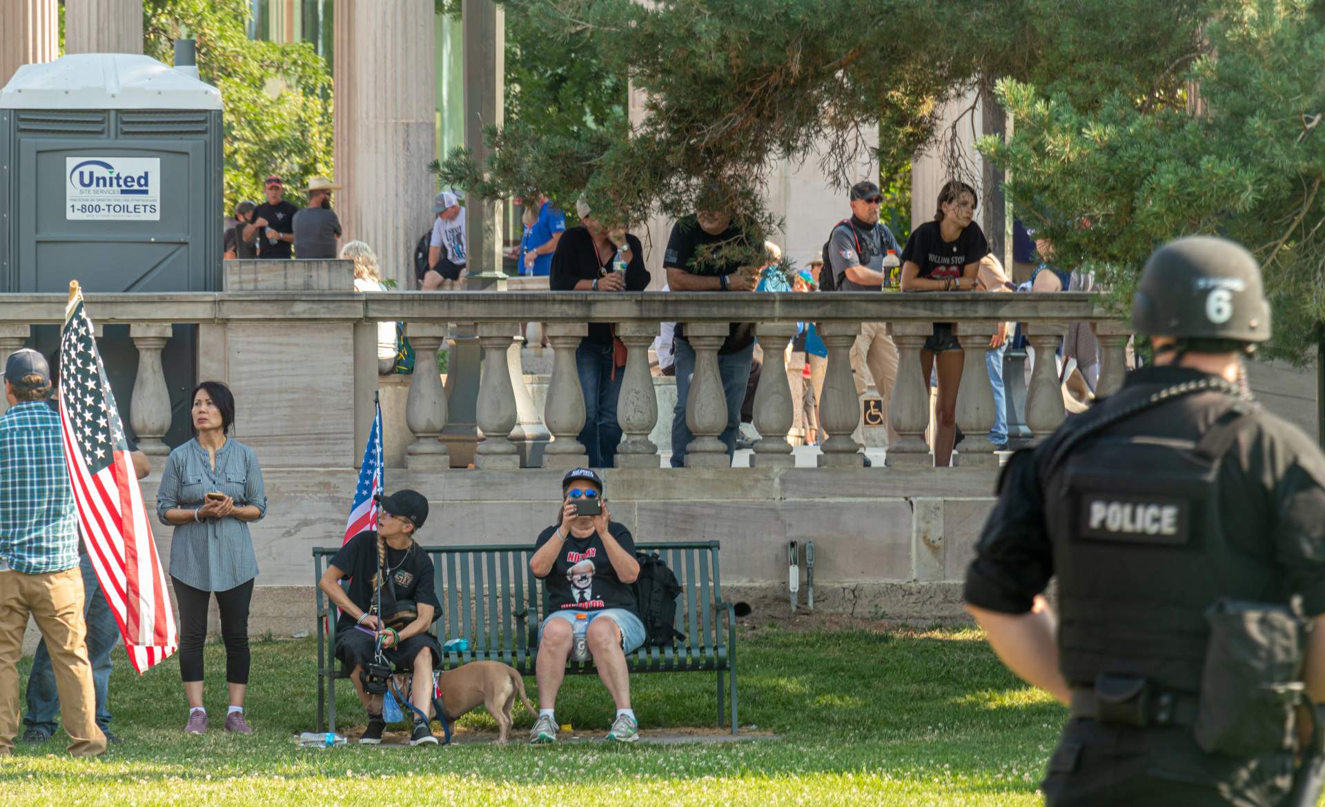 Bootlickers look on as riot police stand between them a fence and about 500 protesters.