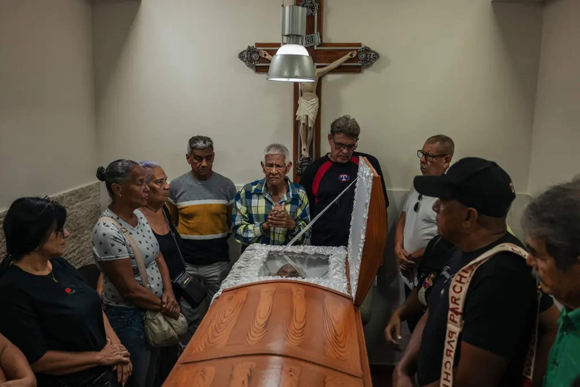The family of Rosa González gathers around her casket. Ms. González, 80, died from her injuries after U.S. airstrikes hit a three-story apartment complex in the raid to "arrest" Maduro.