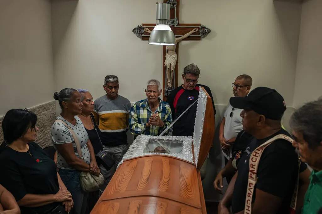 The family of Rosa González gathers around her casket. Ms. González, 80, died from her injuries after U.S. airstrikes hit a three-story apartment complex in the raid to "arrest" Maduro.