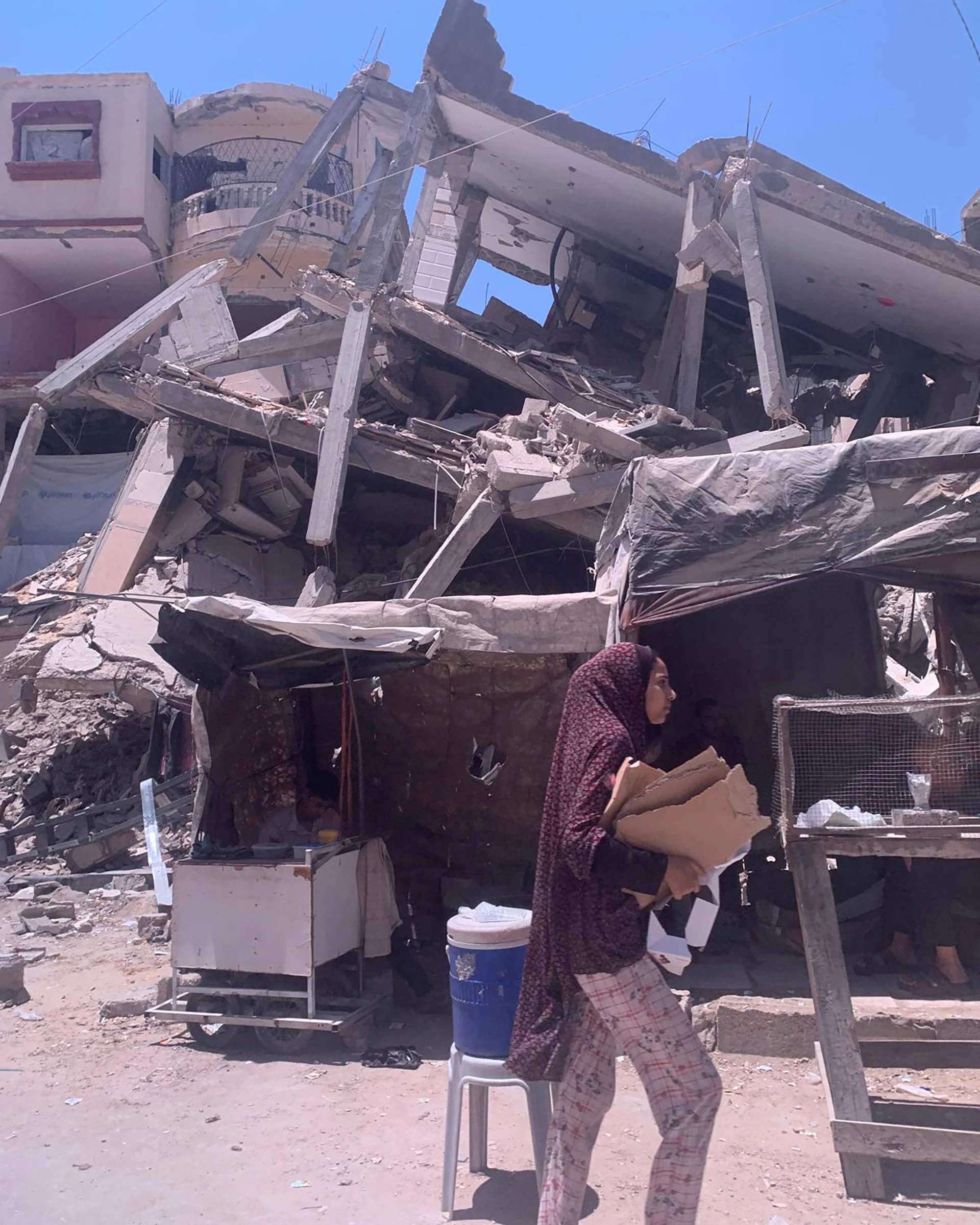 Medical volunteers in Gaza standing near destroyed buildings and rubble providing care to patients