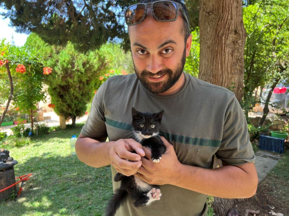 Reuters' journalist Issam Abdallah holds a kitten while posing for a picture in Saaideh, Lebanon, July 4, 2023.