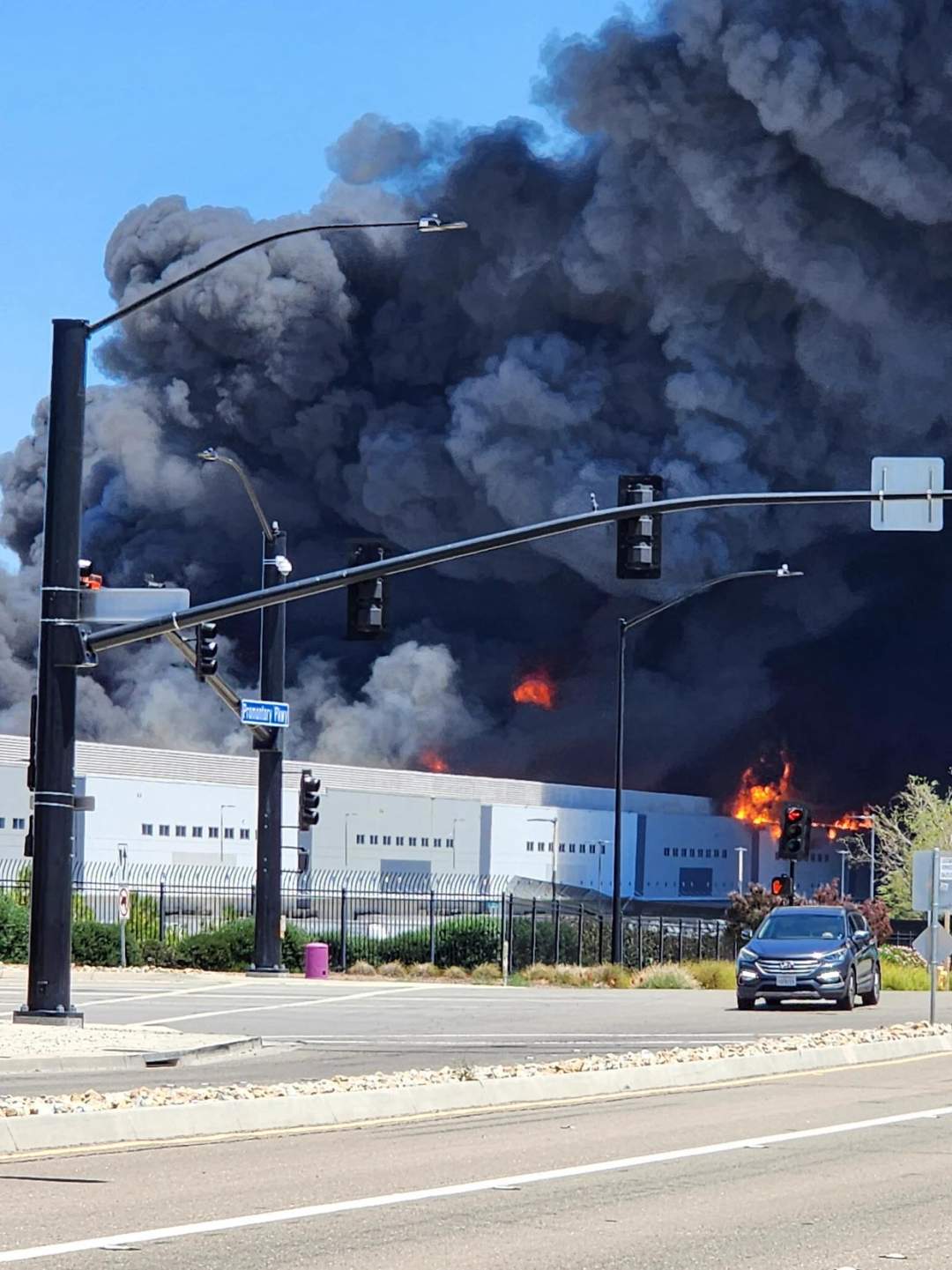 Aerial view of a massive fire engulfing the Medline Industries warehouse in Tracy, California on June 11, 2026. Thick black smoke rises from the burning facility.