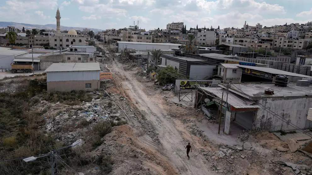 A man walks on a damaged road following an Israeli army raid [Jenin, occupied West Bank Wednesday, Sept. 4, 2024 - Majdi Mohammed)