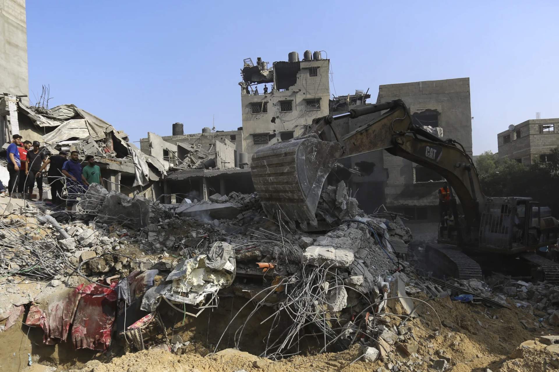 Palestinians inspect the damage of destroyed houses after Israeli airstrikes on Gaza City, Tuesday, Oct. 24, 2023