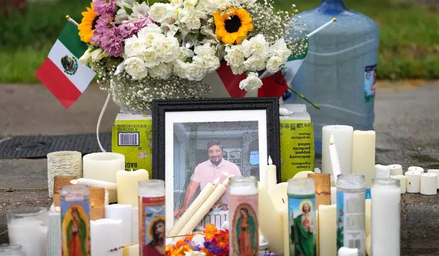 Flowers, candles, and photos at a makeshift memorial on a Houston street where Lorenzo Salgado Araujo was killed by ICE