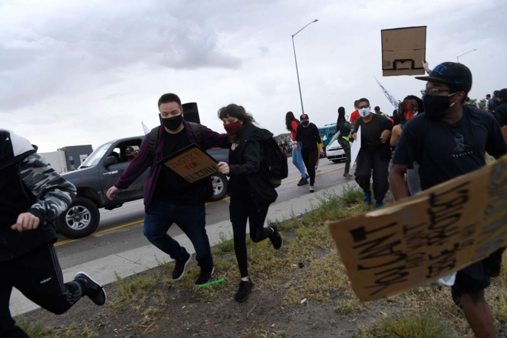 Protesters run off of the interstate as gun shots ring out and the jeep charges toward the crowd. [Radical Edward - Untelevised Media]