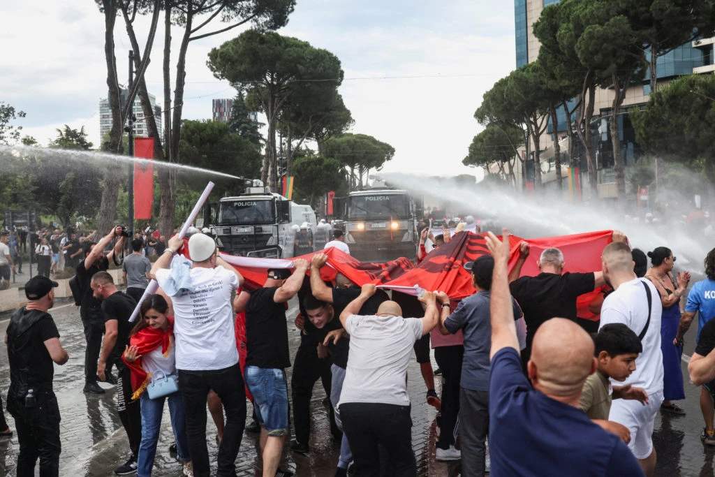 Albanian protesters push against police riot shields and water cannon during clashes in Tirana over Kushner-linked luxury resort