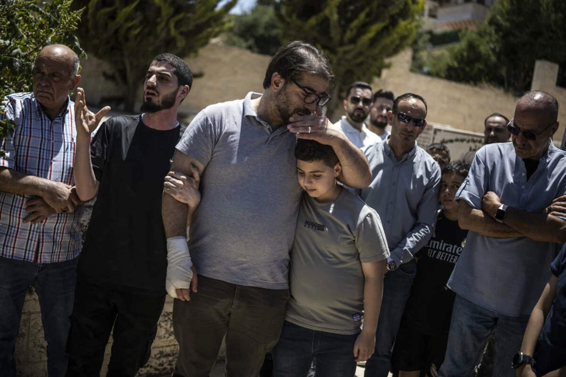 Fahd Abu Haikal comforts his elder son Kinan after burying seven-month-old Sam in Hebron, June 6, 2026.