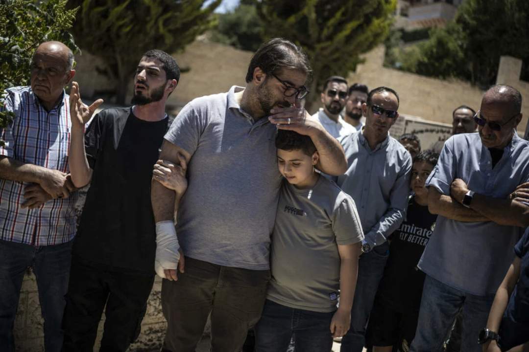 Fahd Abu Haikal comforts his elder son Kinan after burying seven-month-old Sam in Hebron, June 6, 2026.