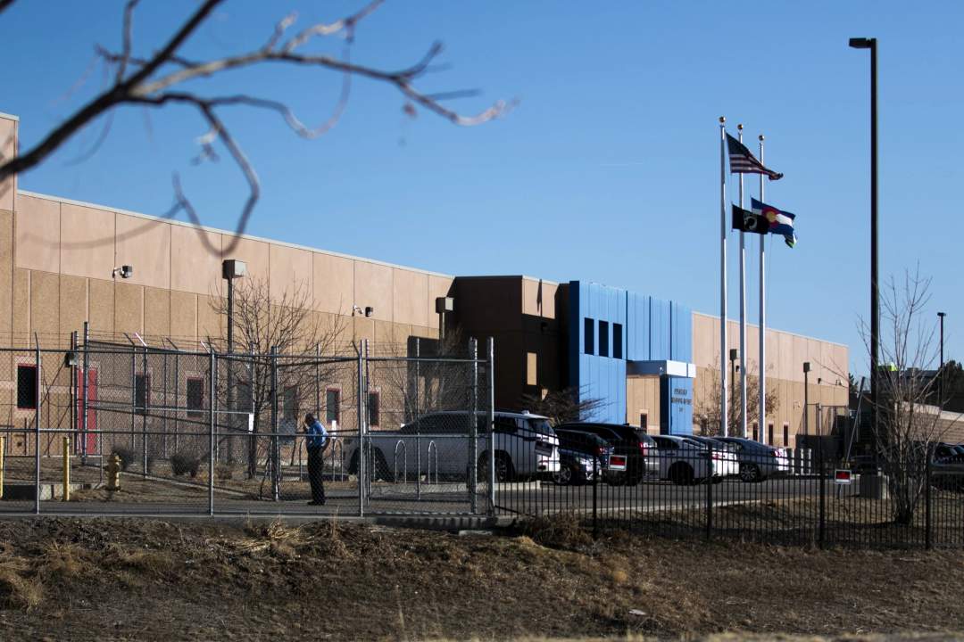 Exterior view of the Aurora ICE Processing Center detention facility showing fencing and security infrastructure