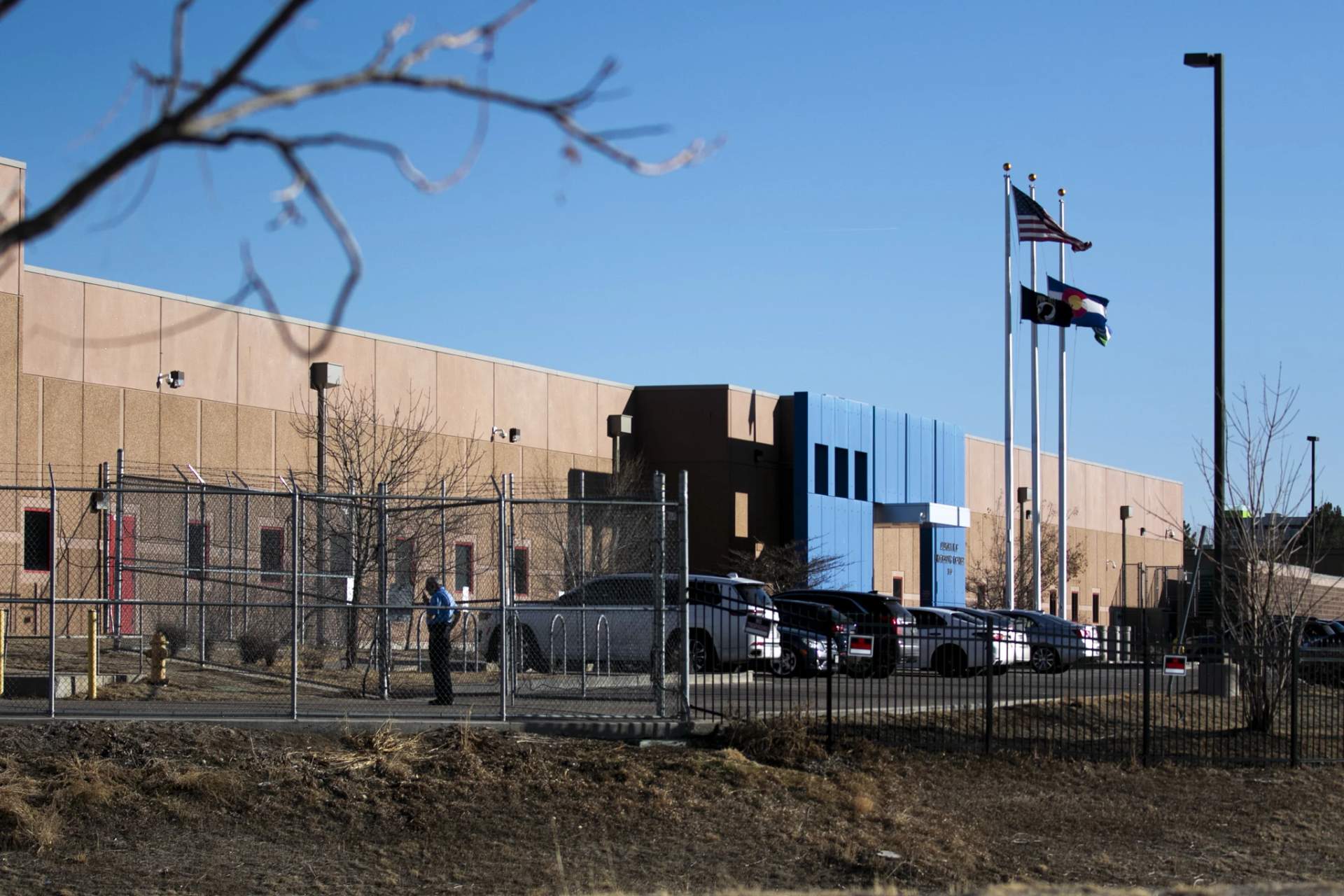 Exterior view of the Aurora ICE Processing Center detention facility showing fencing and security infrastructure
