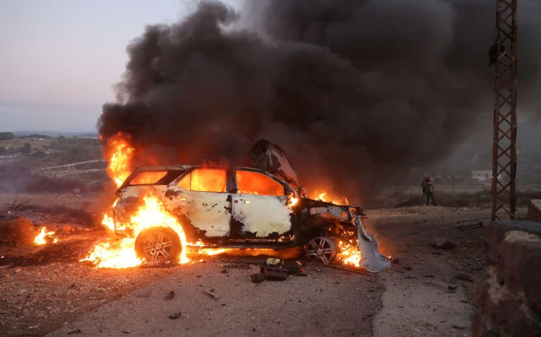 A journalist's car burns at the site where an explosion killed Reuters visual journalist 