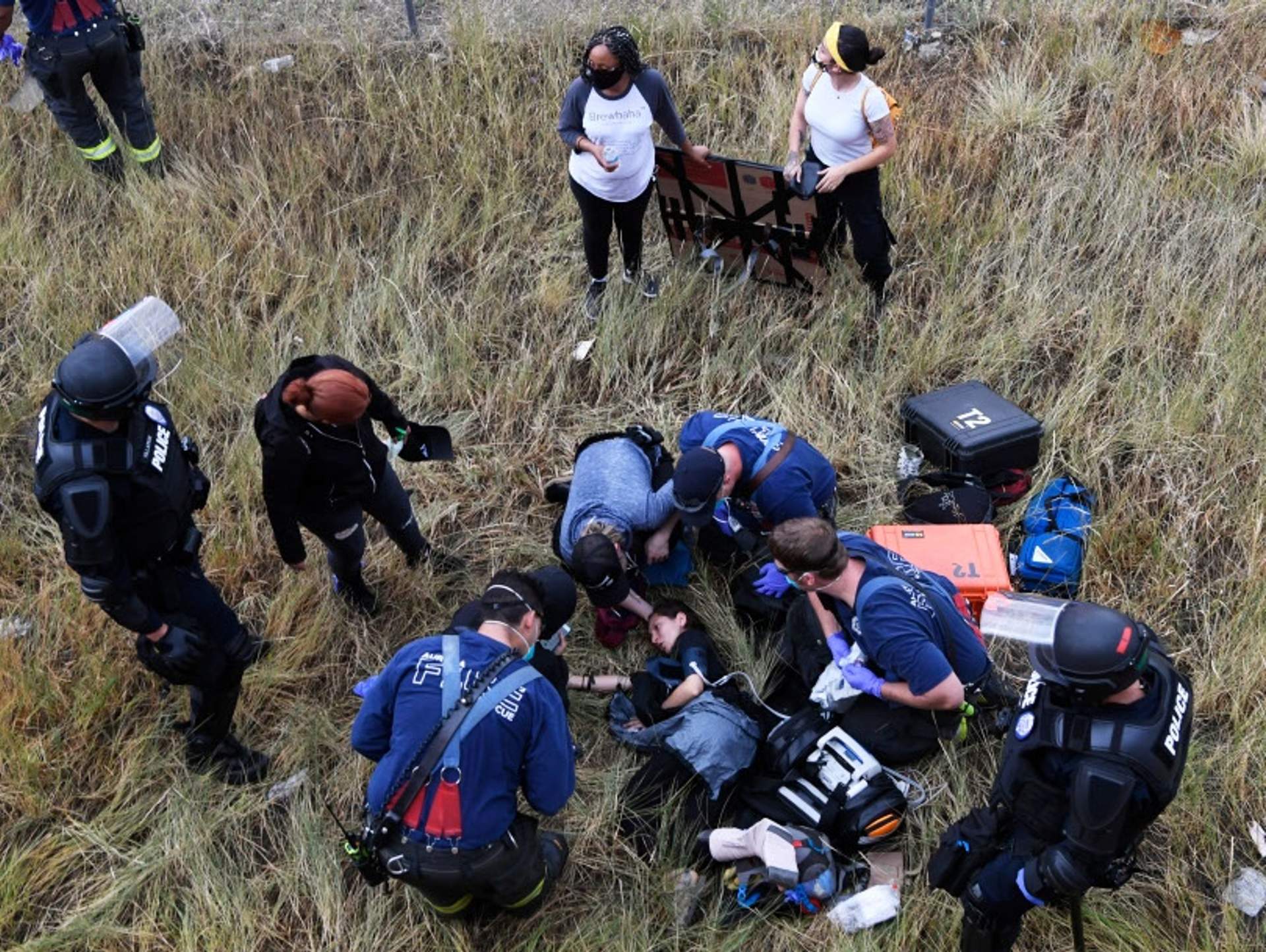 Medics attend to protester injured after jumping over a retaining wall to escape the jeep.
