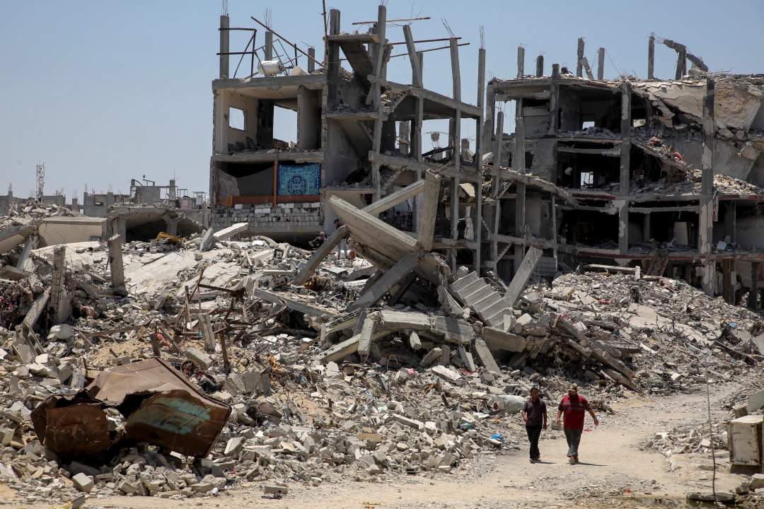 Vast landscape of destroyed multi-story buildings reduced to rubble in Khan Younis, Gaza, under clear sky