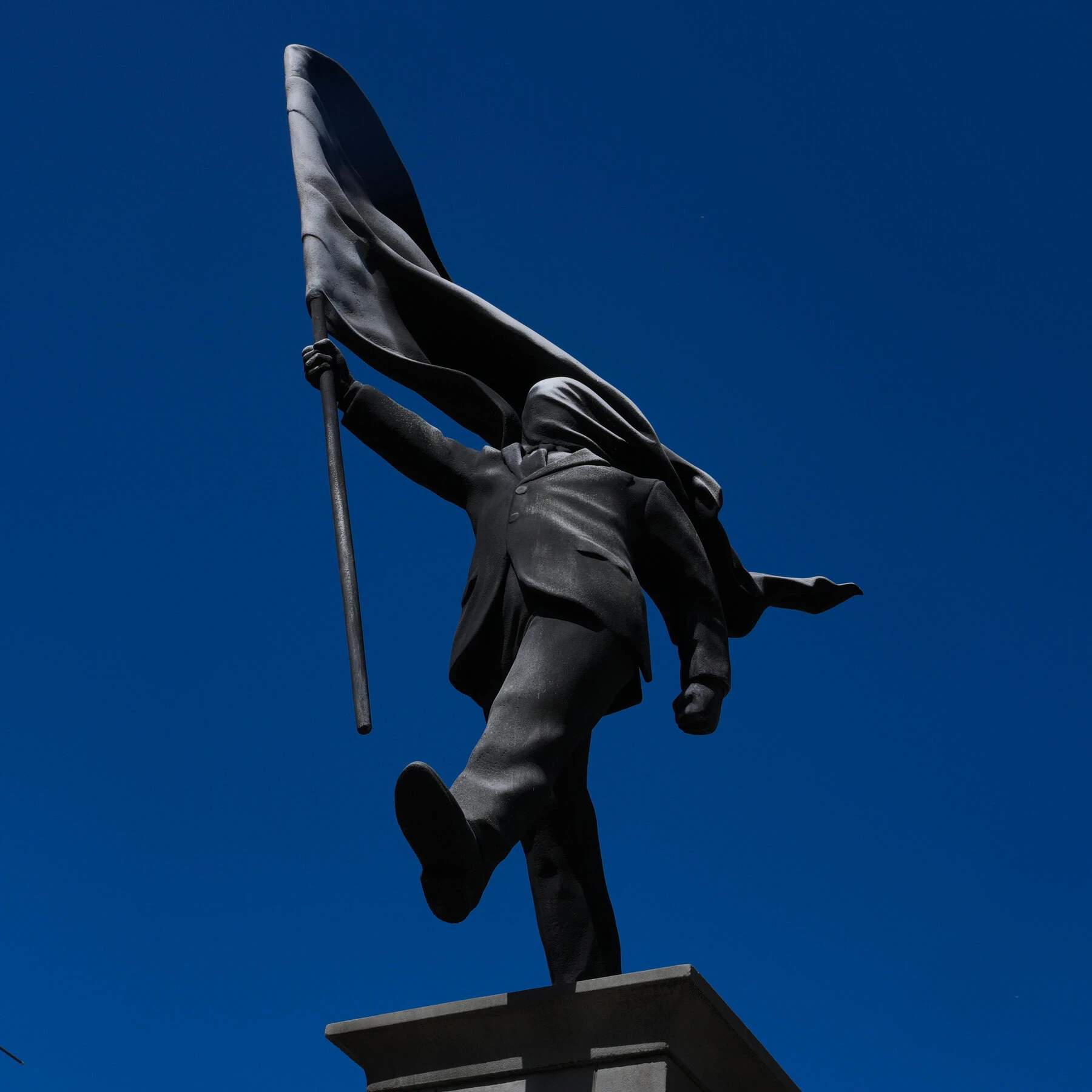 Suited figure blindly marching off his pedestal