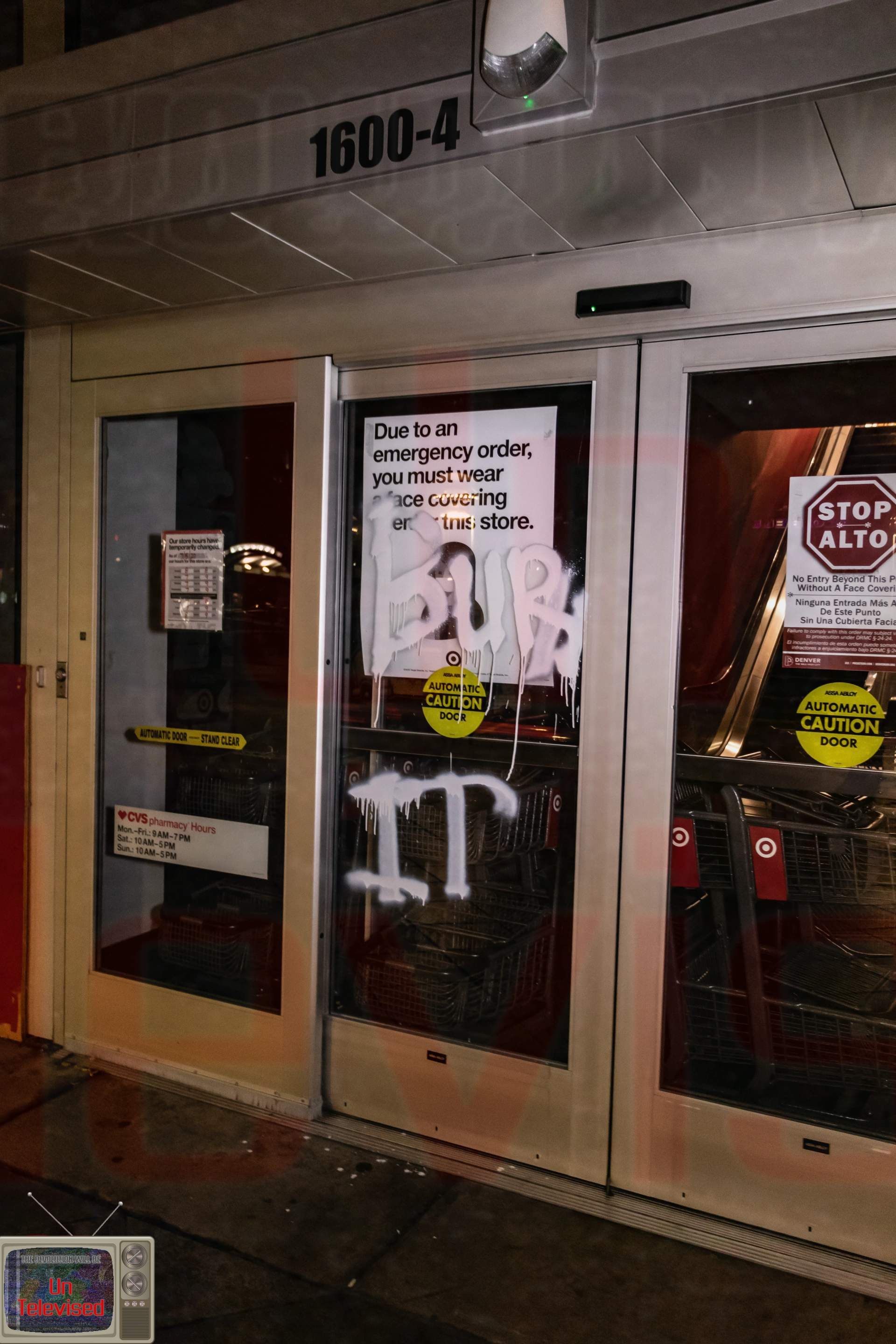  The CVS/Target entrance doors with "BURN IT" spray-painted in white over a posted face-covering notice. [Radical Edward - Untelevised Media]