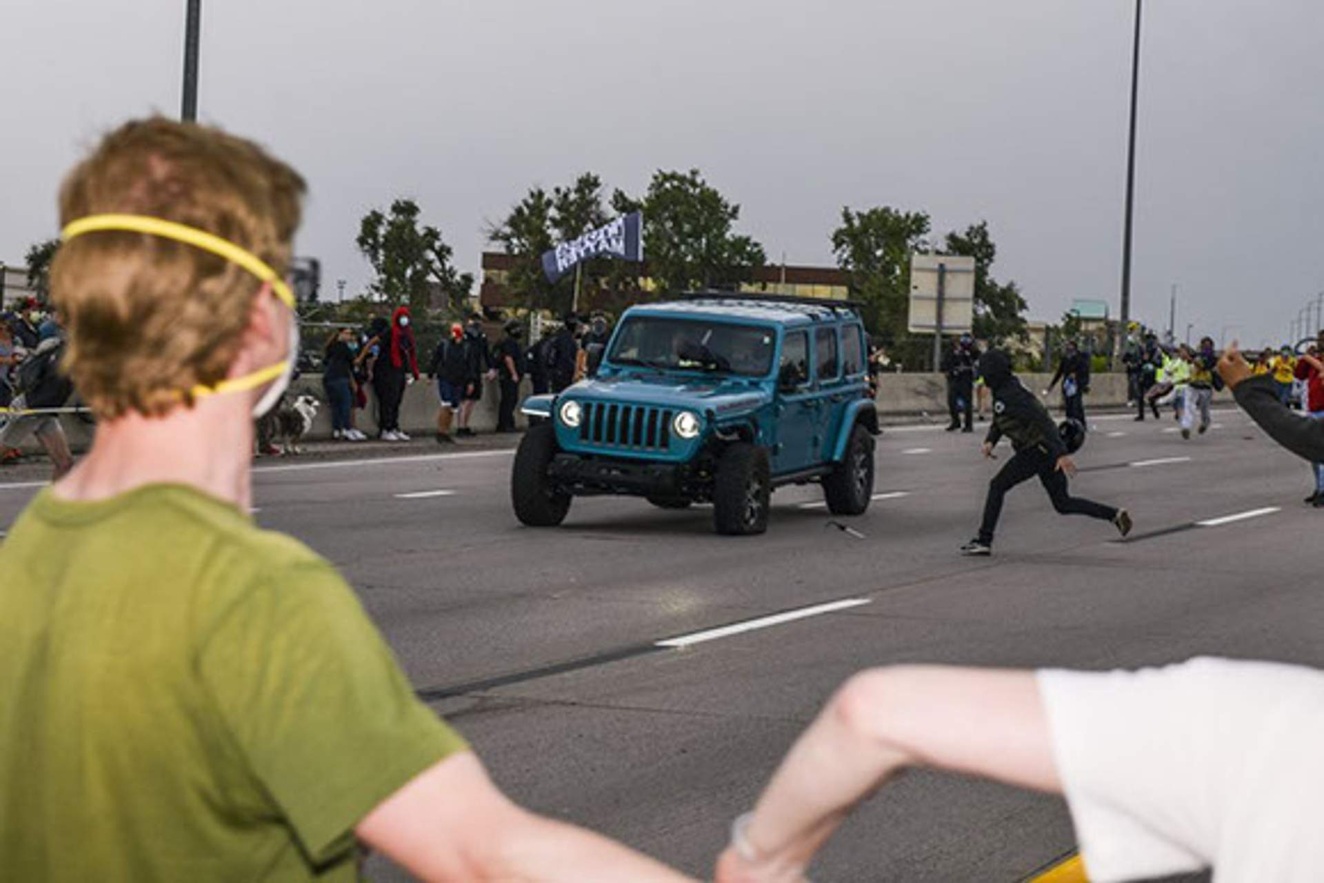 Blue jeep speeds towards back side of protest as several people throw items at the jeep. [Radical Edward - Untelevised Media]