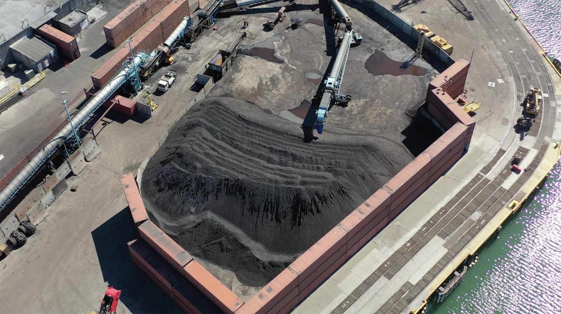 Aerial photograph of the Levin-Richmond Terminal industrial waterfront showing large piles of coal, conveyor systems, and storage structures along San Francisco Bay