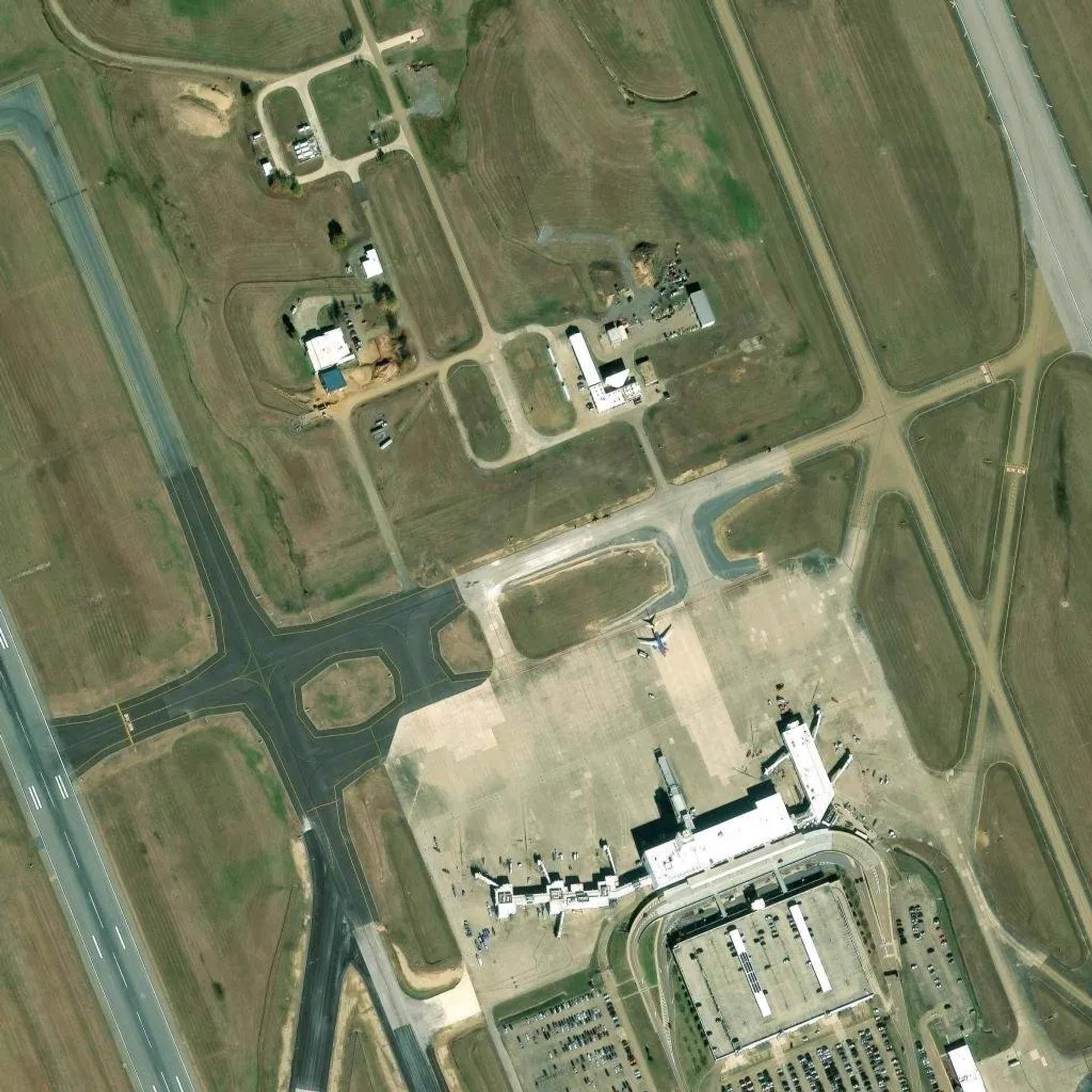 Satellite view of Jackson-Medgar Wiley Evers International Airport in Rankin County, showing runways, terminal, and surrounding undeveloped land that the city exempted from its data center moratorium