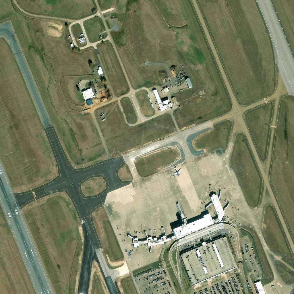 Satellite view of Jackson-Medgar Wiley Evers International Airport in Rankin County, showing runways, terminal, and surrounding undeveloped land that the city exempted from its data center moratorium