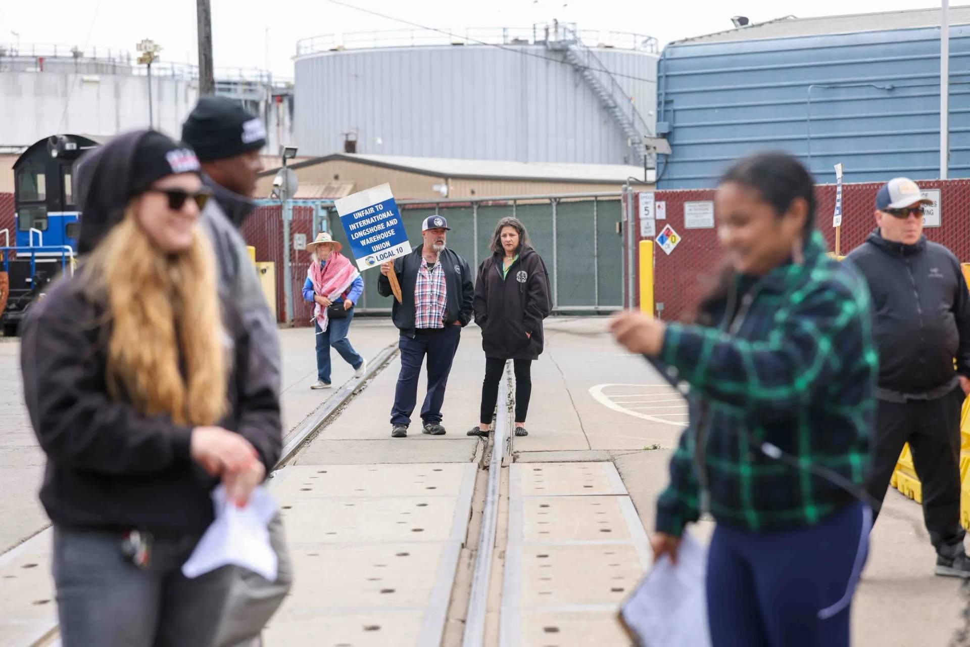 Union workers and supporters gather near the waterfront at a rally in Richmond CA holding signs and ILWU flags during the C&H Sugar strike