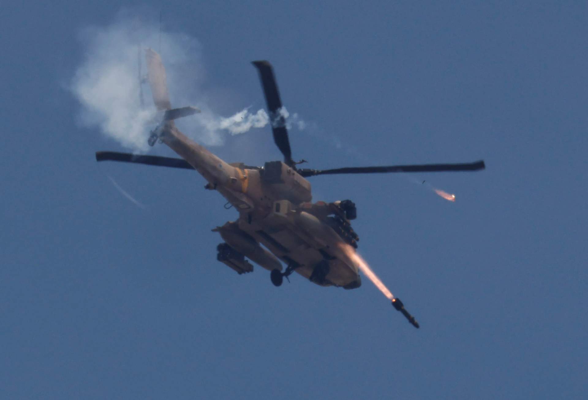 Israeli Apache helicopter firing a missile with smoke trail seen from ground near the Israel-Gaza border
