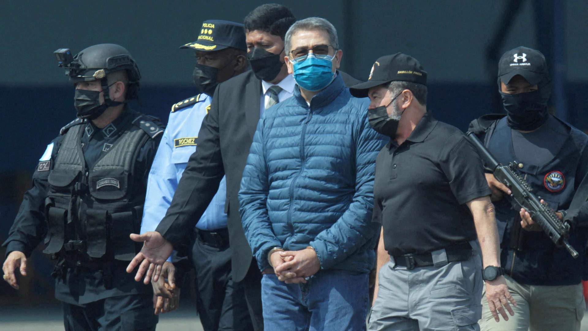 Juan Orlando Hernandez being escorted by federal authorities after being released arriving back to Honduras