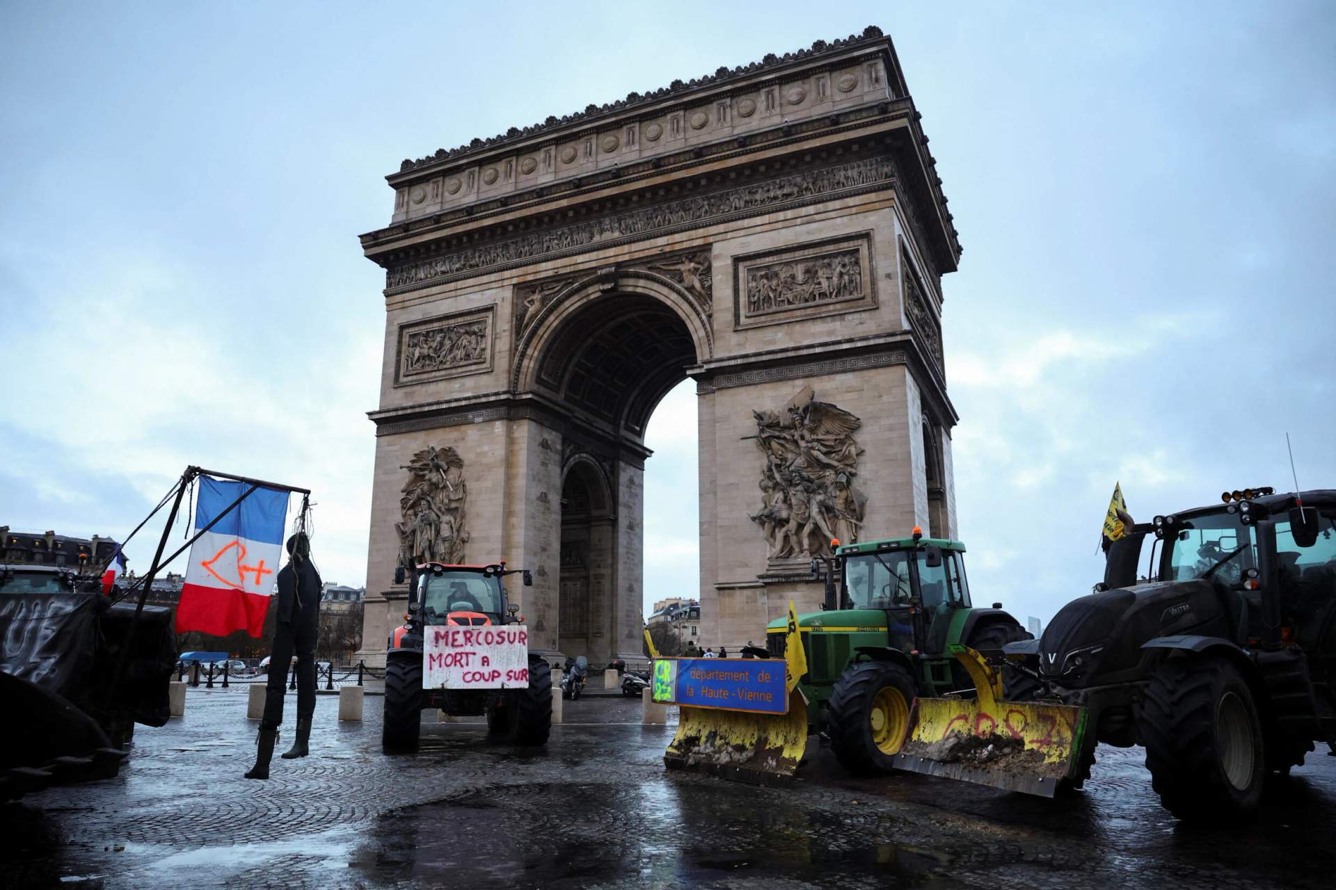Rows of farm tractors parked along Avenue des Champs-Elysees with the Arc de Triomphe in the background during the French farmers protest in Paris, January 2026