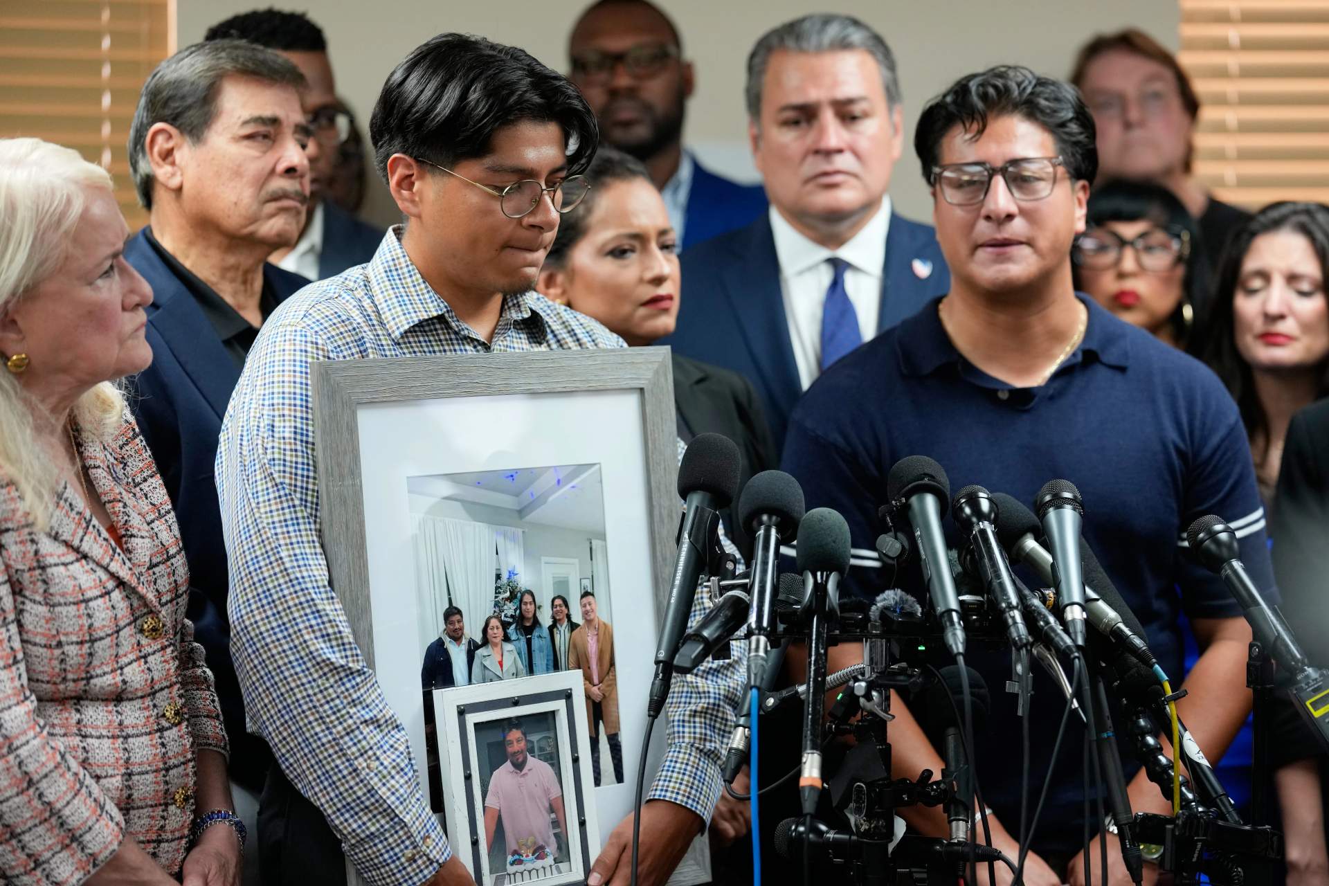Ronaldo Salgado, son of Lorenzo Salgado Araujo, holds up a photograph of his father during a press conference alongside his brother in Houston