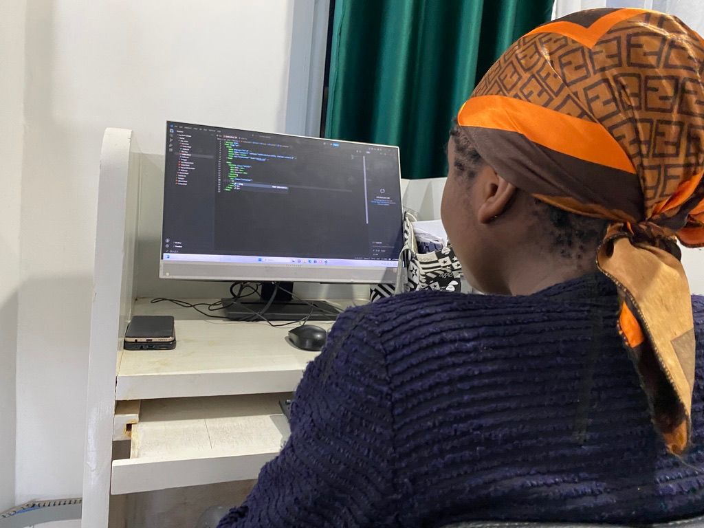 A student writing HTML and CSS by hand in a code editor