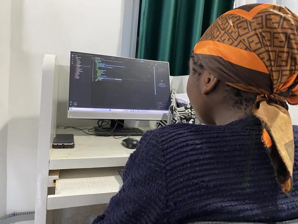 Naomi writing her portfolio by hand in a code editor at the Togeva STEAM Summer School 2026