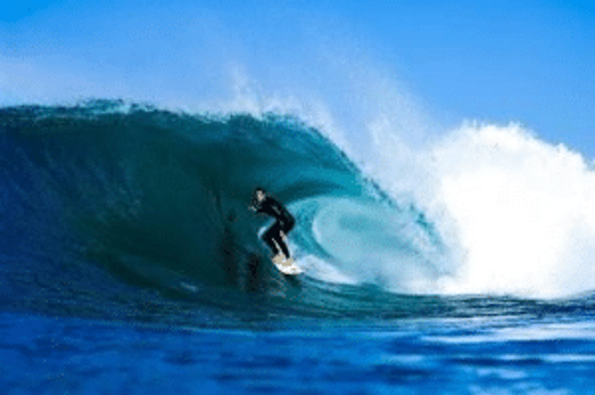 Surfer riding the wave in blue water.