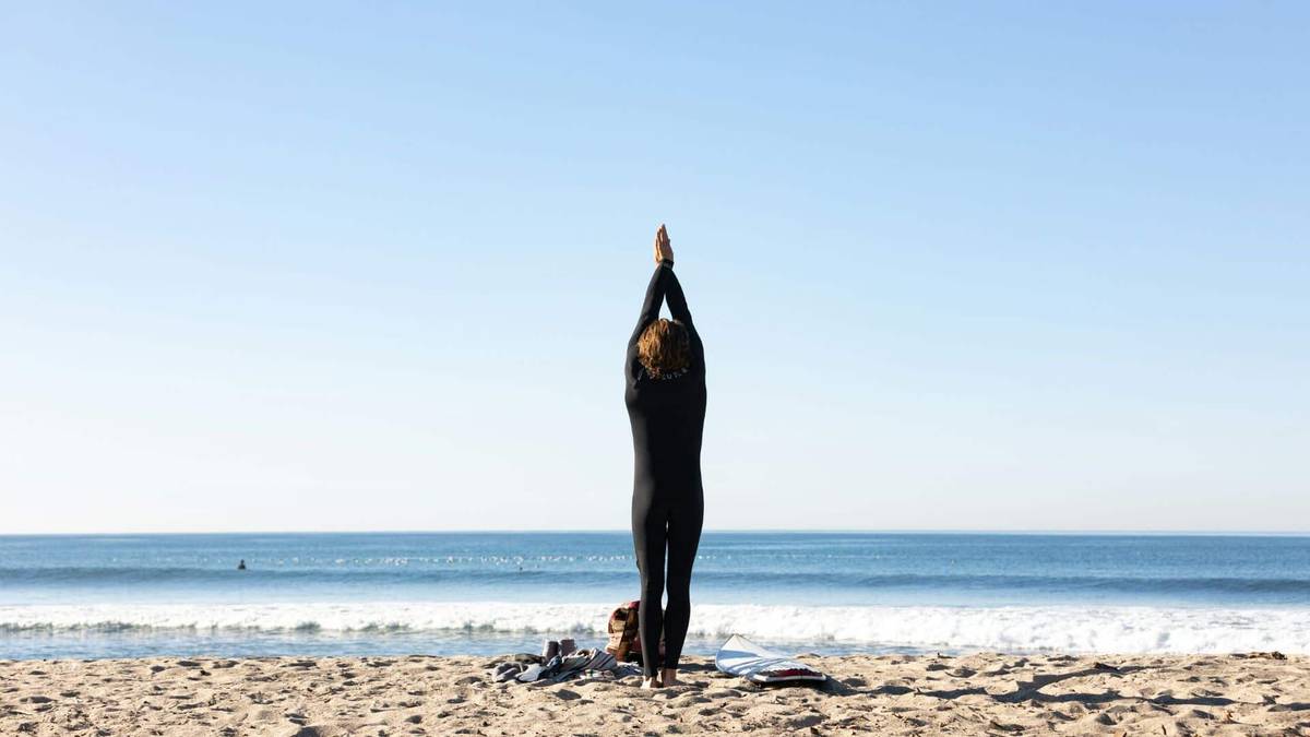 An image of a surfer stretching before a surf
