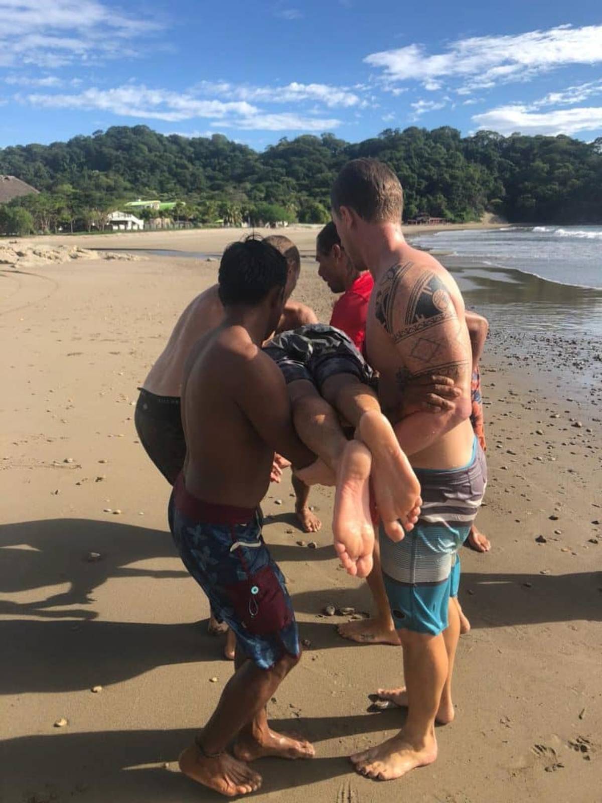 4 guys holding a man horizontally in a lifesaving course