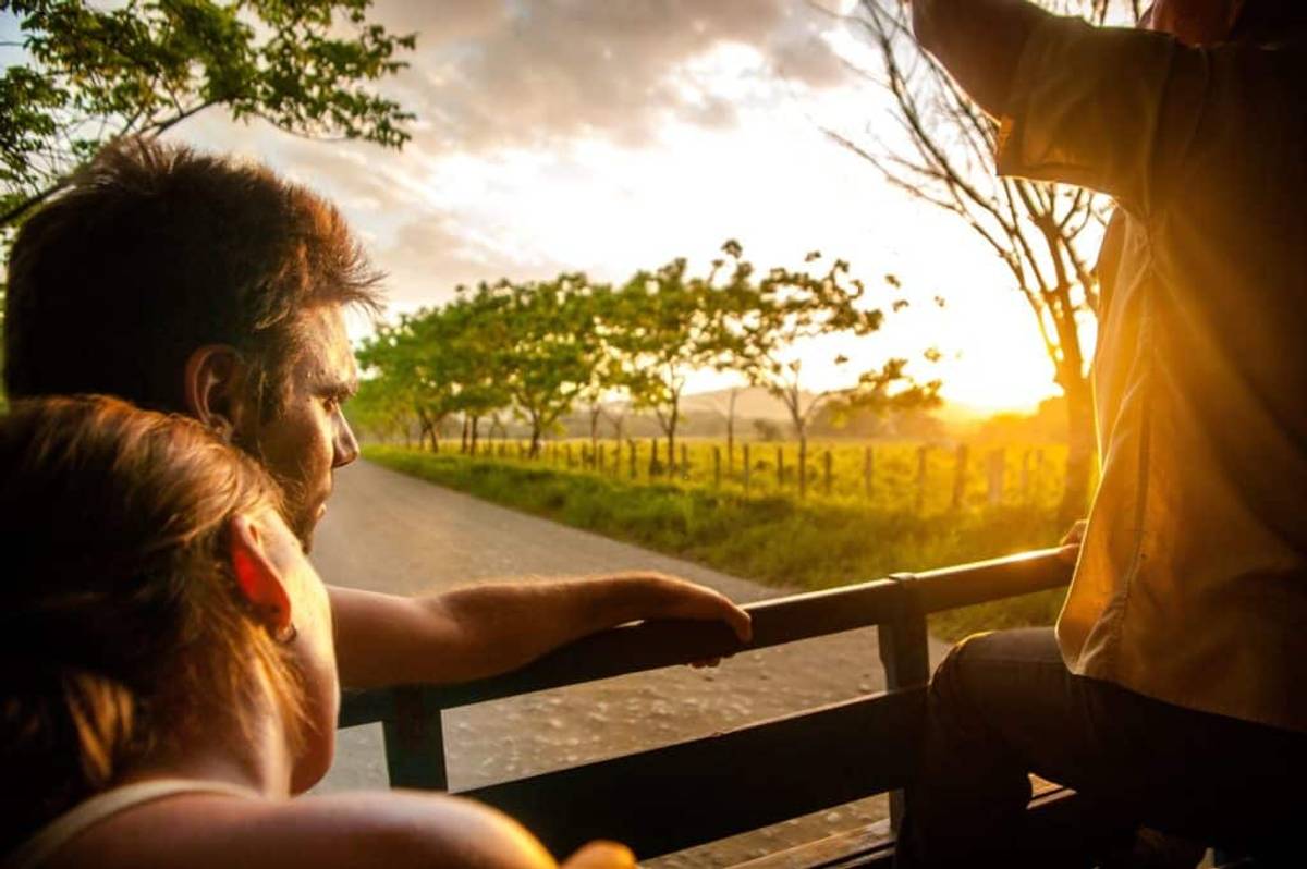 Couple enjoying Costa Rican sunset from back of truck