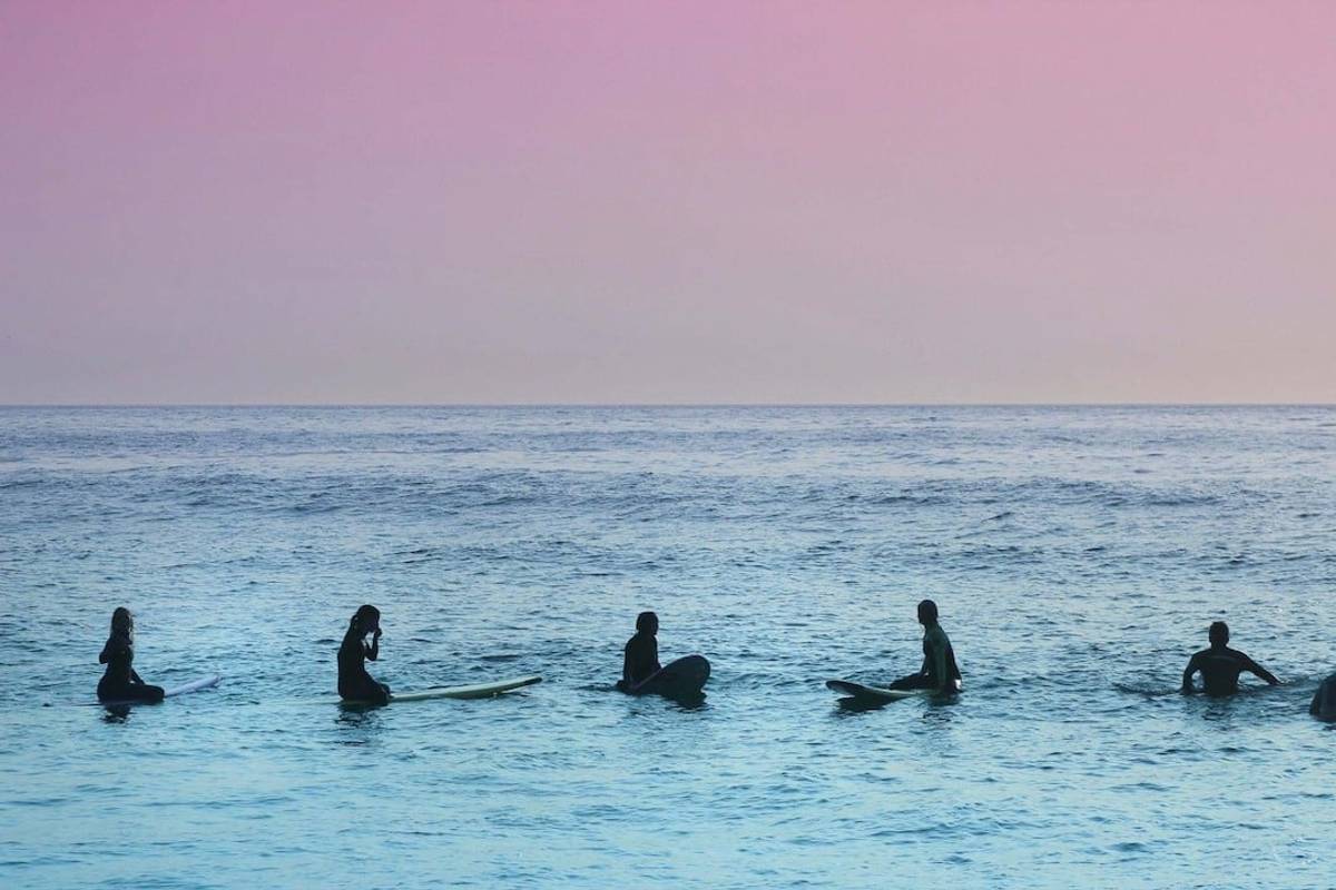 Surfers lineup at sunset