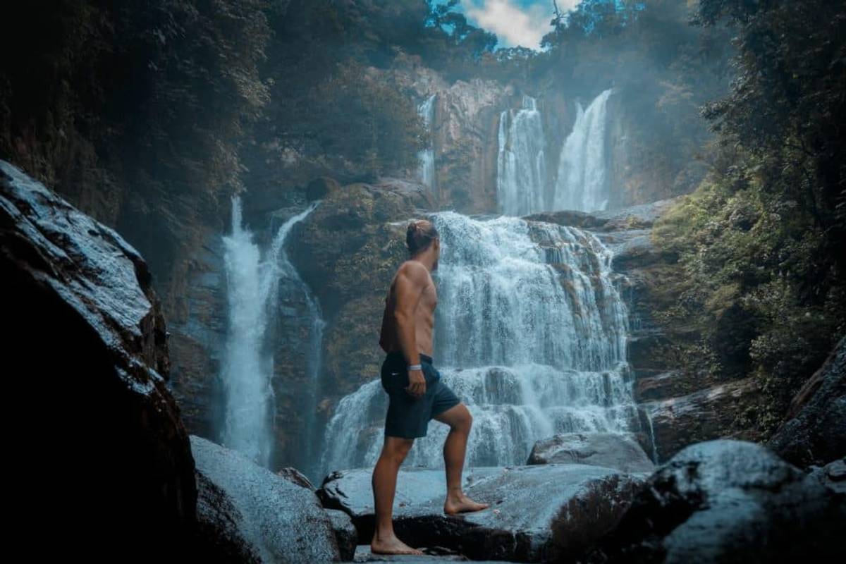 Man standing in front of a waterfall