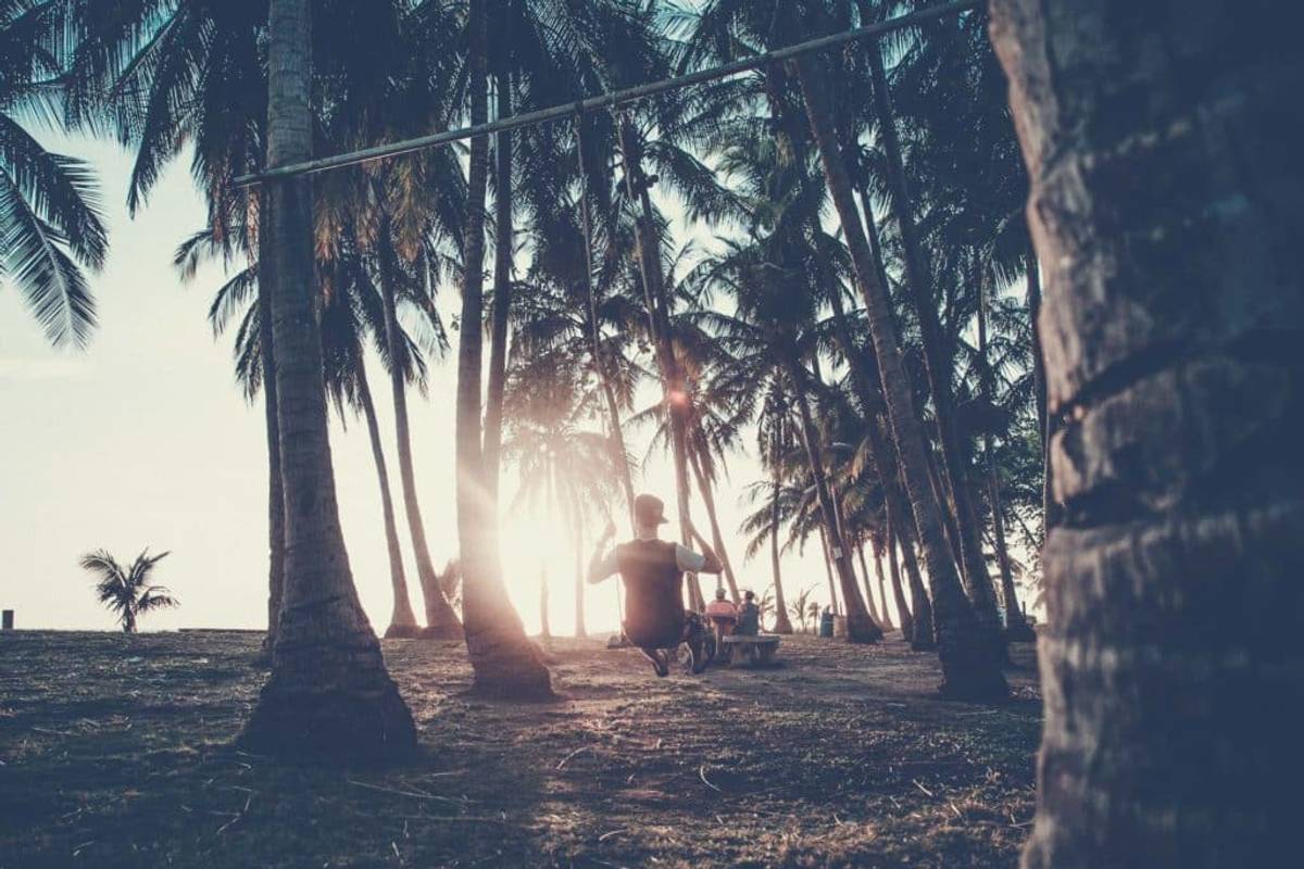 Guy watching the sunset while sitting on a swing in Costa Rica